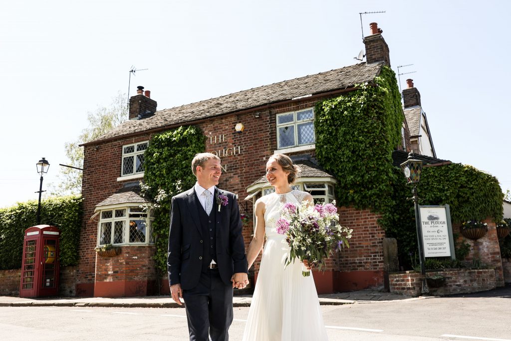 Bride and groom walking towards the photographer at The Plough Inn