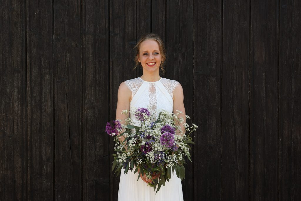 Bride stood in front of the old barn door