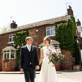 A newly married couple in front of The Plough Inn at Eaton