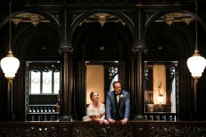 Elegant portrait of the bride and groom, perfectly lit in the historic Balcony Room at Crewe Hall.