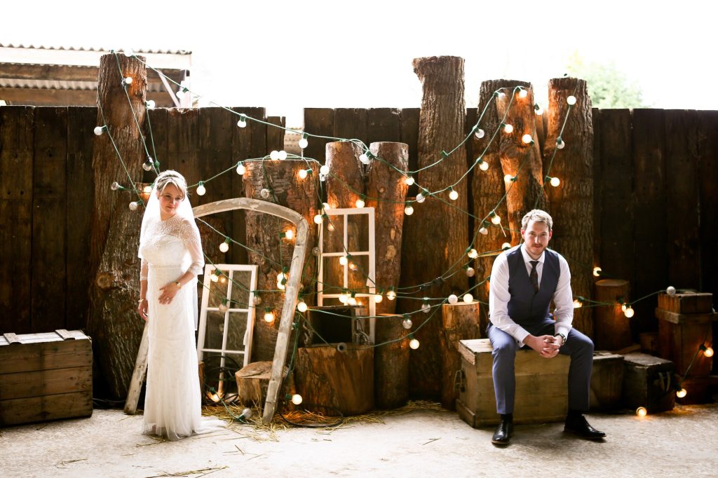 Elegant, posed bridal portrait of the couple standing in the light-filled, rustic ceremony barn at Owen House Wedding Barn