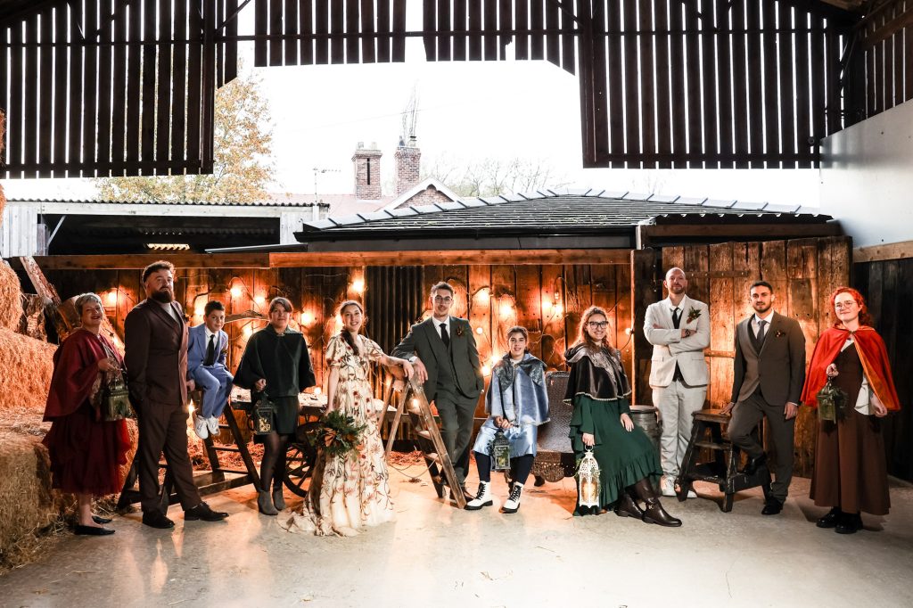 A stylish wedding party portrait captured against the iconic brick and timber backdrop of Owen House Wedding Barn