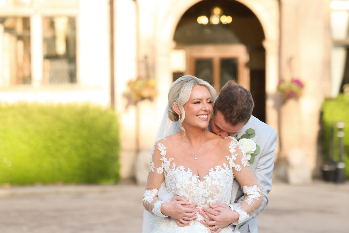 Romantic embrace of bride and groom outside the entrance of Rookery Hall.