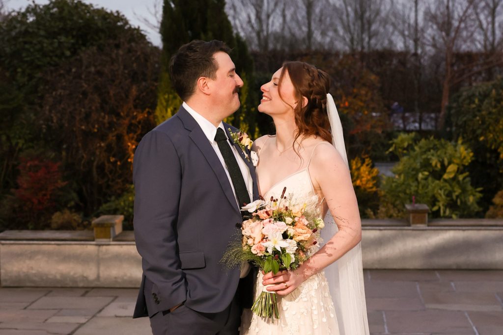 Newlyweds sharing a romantic moment in the soft twilight glow at Owen House Wedding Barn