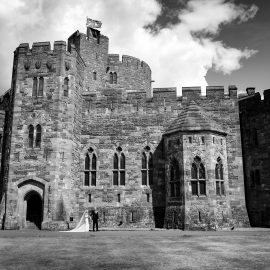 Peckforton Castle wedding photography showing couple in front of castle entrance