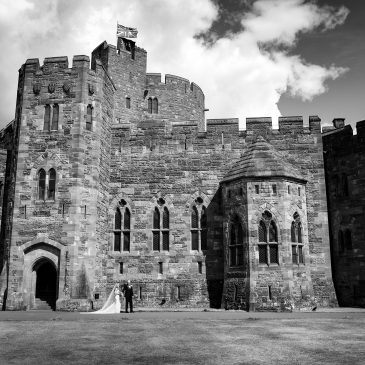 Peckforton Castle wedding photography showing couple in front of castle entrance