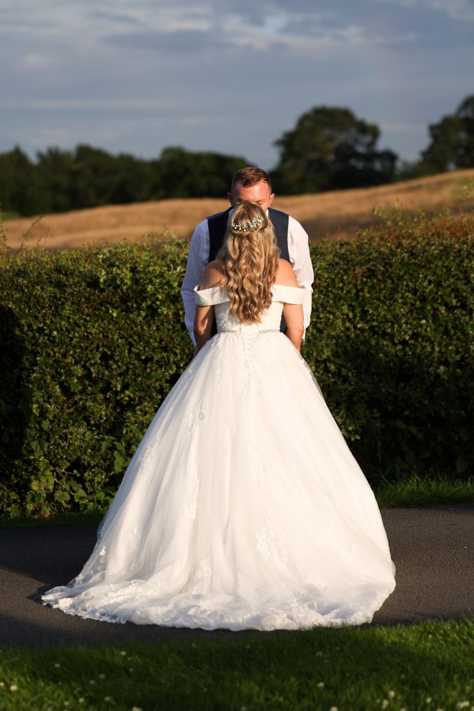 Bride and groom sharing a tender moment in the warm evening light.